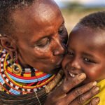 African mother from Samburu tribe kissing her baby , Kenya, Africa. Samburu tribe is one of the biggest tribes of north-central Kenya, and they are related to the Maasai.